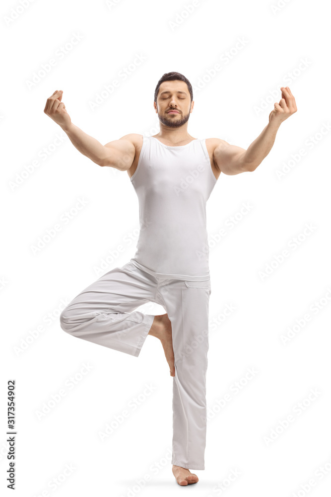 Man in a standing position practicing a yoga pose Man in a standing position practicing a yoga pose