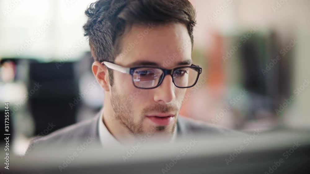 Handsome businessman working on an office. Focused young man typing on a laptop. Dolly shot. Daylight. Technology. 
