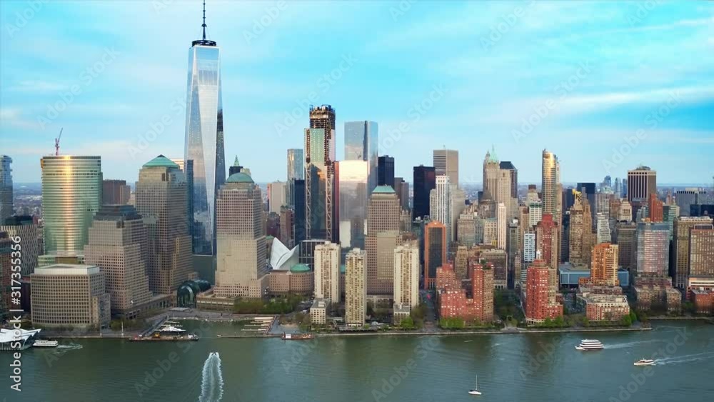 Lower Manhattan skyline and traffic passing by. Famous skyscrapers in the Financial District of New York City. United States, North America. Shot from a helicopter.  