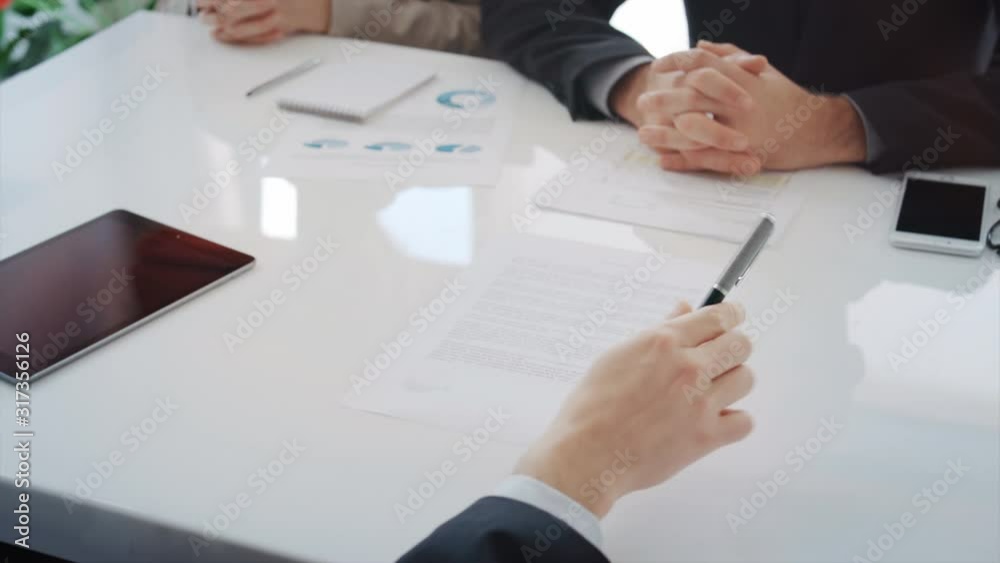 Businesspeople signing contract. Shaking hands after making a deal. Blurred and fake signature. Businesspeople signing contract. Shaking hands after making a deal. Blurred and fake signature.