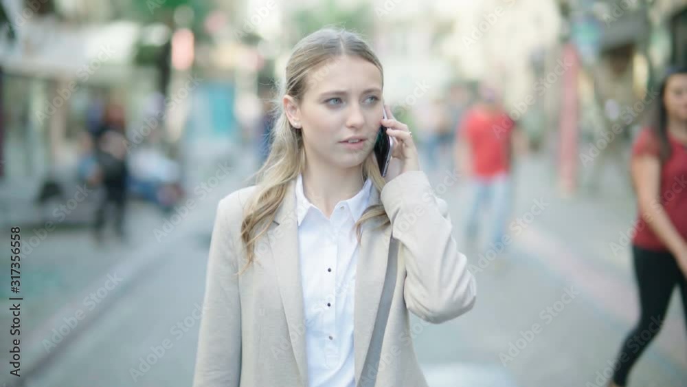Beautiful businesswoman using a smart phone in a crowded city street. Technology. Beautiful businesswoman using a smart phone in a crowded city street. Technology.