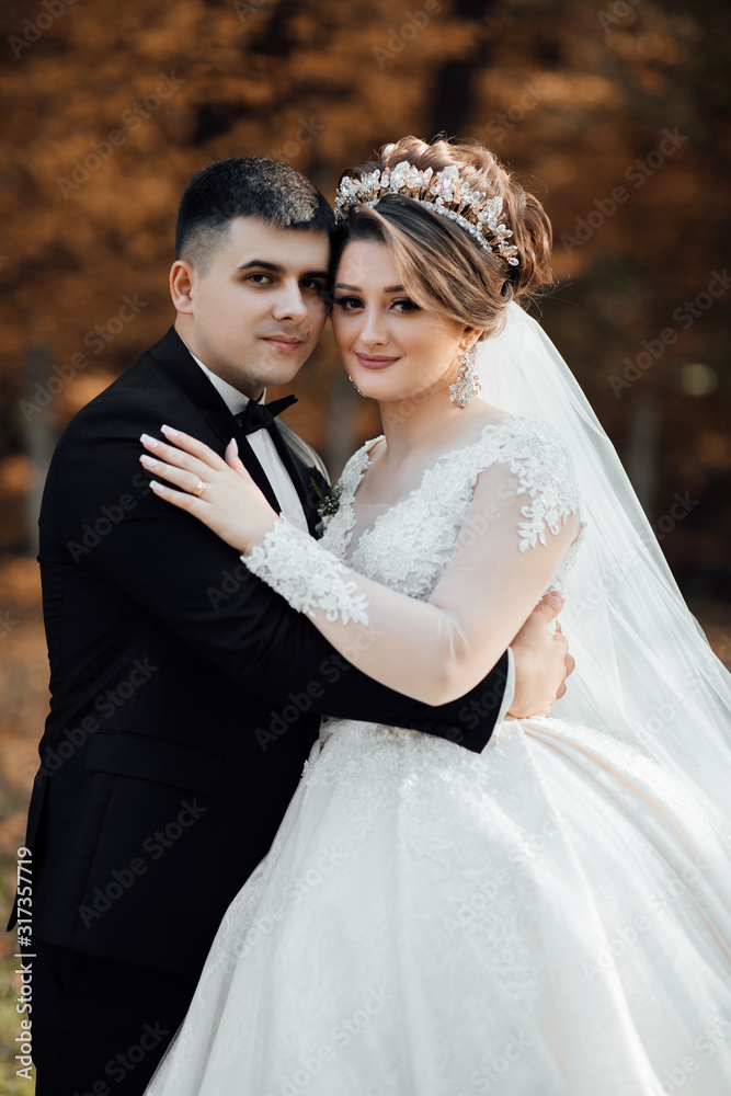Autumn wedding. Close-up of newlyweds smiling and caressing. Loving wedding couple. Lovely young couple in love glow with happiness together. Newlyweds smile at each other at wedding day. Autumn wedding. Close-up of newlyweds smiling and caressing. Loving wedding couple. Lovely young couple in love glow with happiness together. Newlyweds smile at each other at wedding day.