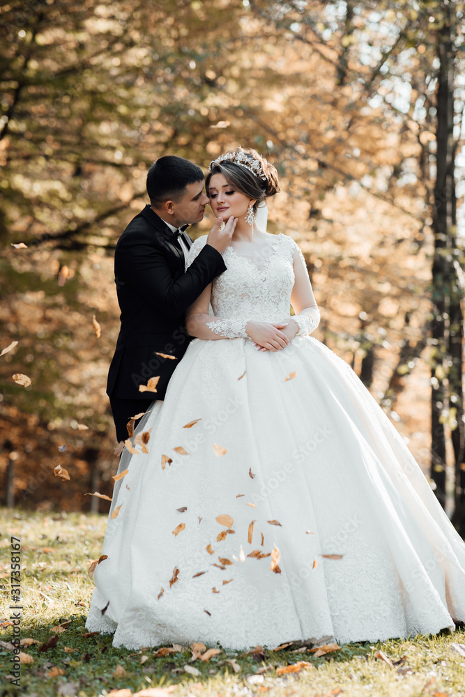 Beautiful bride with modern bouquet pose with stylish groom in autumn park. Sensual romantic moment. Wedding. Stylish and beautiful. Beautiful bride with modern bouquet pose with stylish groom in autumn park. Sensual romantic moment. Wedding. Stylish and beautiful.