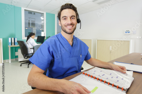 portrait of male medical secretary wearing headset