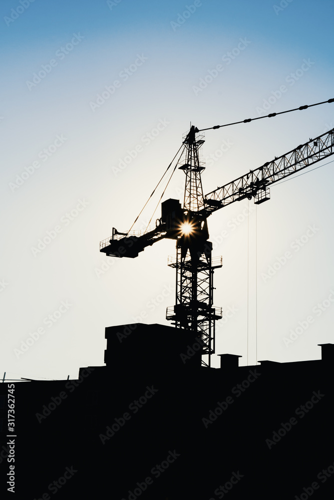 Industrial construction cranes and building site over sunset stormy sky. grunge filter photo Industrial construction cranes and building site over sunset stormy sky. grunge filter photo