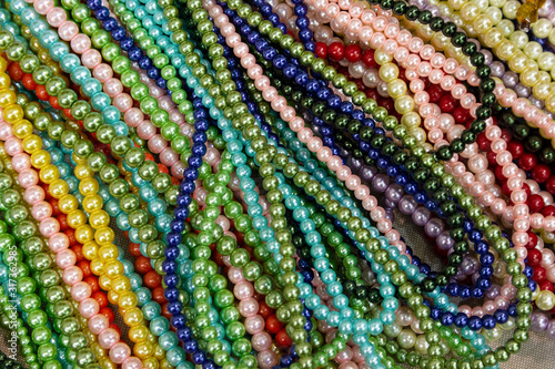Bright background of handmade strands of colorful beads at outdoor crafts market