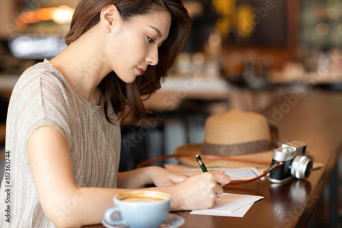 Elegant woman writing postcard in cafe photo