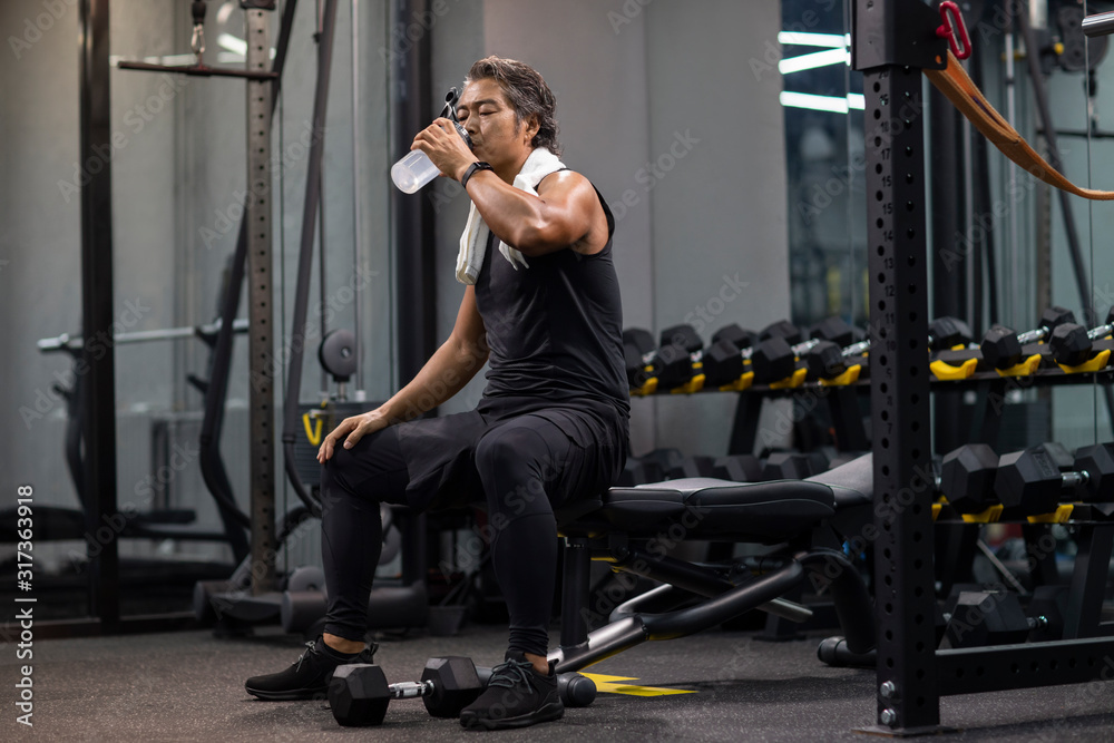 Mature man resting after exercising at gym Mature man resting after exercising at gym