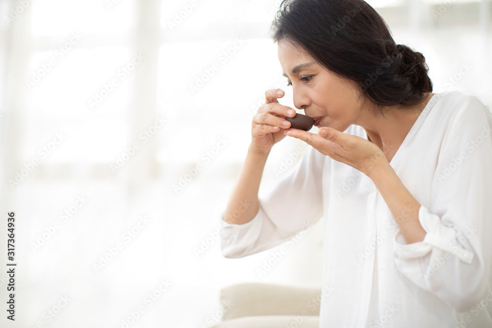 Mature woman drinking tea in living room