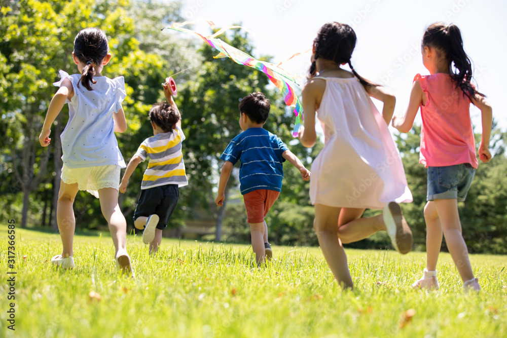 Happy children running with a kite on meadow Happy children running with a kite on meadow