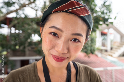 Content young Asian female on vacation with colorful head shawl smiling and looking at camera at hotel at Sri Lanka  photo