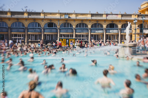 Budapest Spa Szechenyi Thermal Bath spa swimming pool with blue sky in summer day with a crowd of people