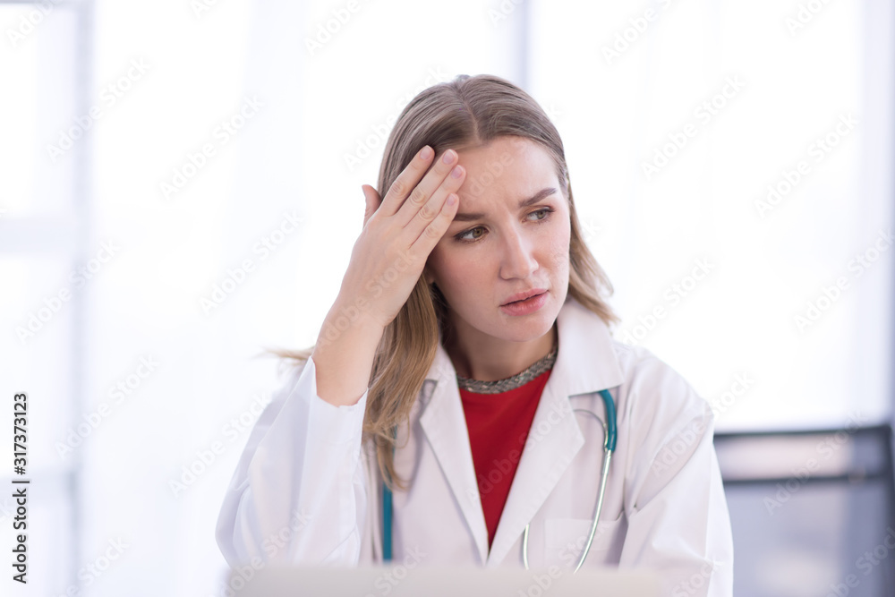 Portrait Of Female Doctor Wearing White Coat with stethoscope, and felt stressed and worried about the patient. Portrait Of Female Doctor Wearing White Coat with stethoscope, and felt stressed and worried about the patient.