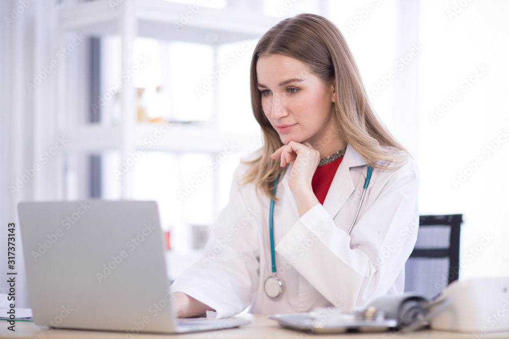 The female doctor wore a white robe with headphones and look at to laptop. The female doctor wore a white robe with headphones and look at to laptop.