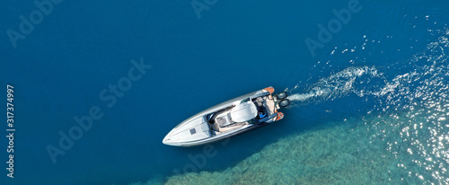 Aerial drone top down ultra wide photo of inflatable speed boat cruising in high speed in deep blue Aegean sea