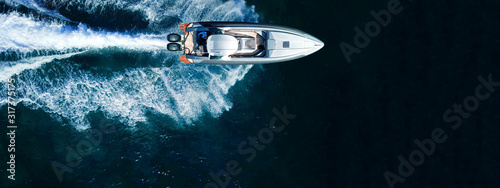 Aerial drone top down ultra wide photo of inflatable speed boat cruising in high speed in deep blue Aegean sea