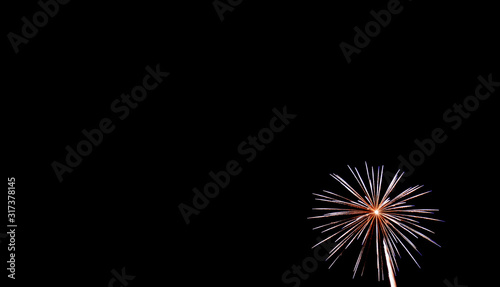 Small white starburst firework in lower right hand corner with black background