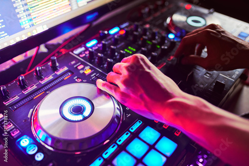 Dj mixes the track in the nightclub at a party