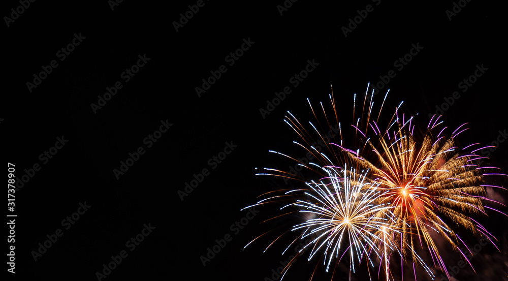 White and gold starburst fireworks with pink highlights with a black background