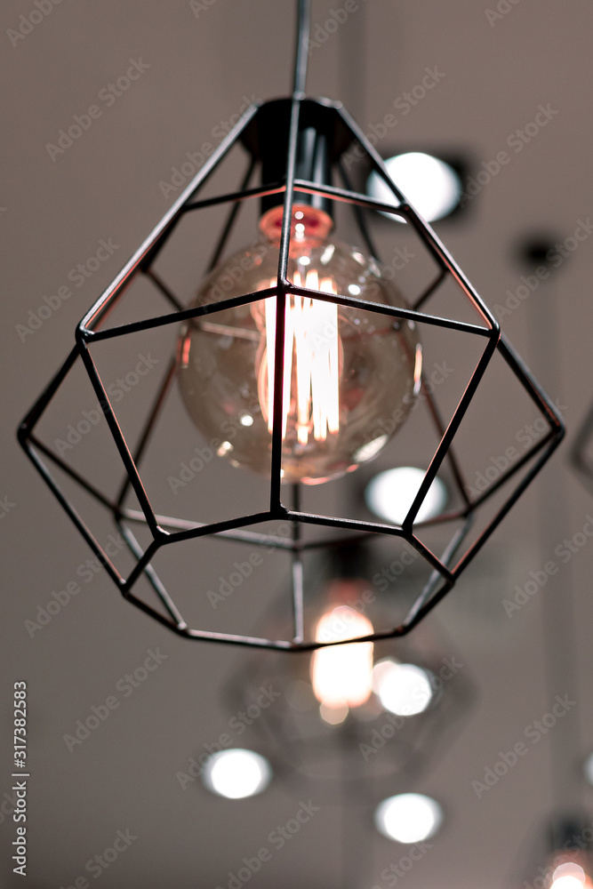 Ceiling light with a frame lampshade with a vintage incandescent bulb in a commercial room