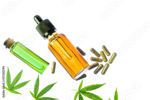 Glass bottles with Cannabis CBD oil  CBD pills and THC tincture and hemp leaves on white background