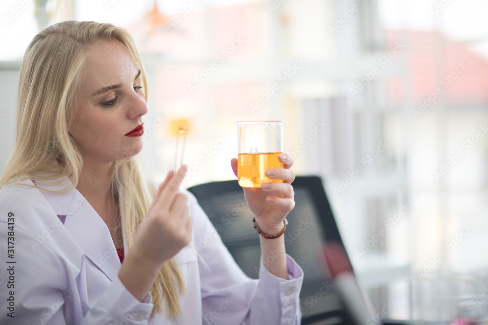 A white female scientists are experimenting with chemicals in the laboratory. A white female scientists are experimenting with chemicals in the laboratory.