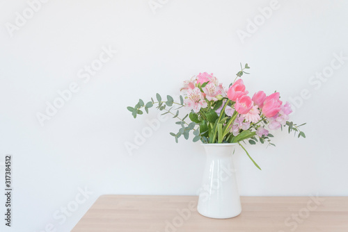 白い花瓶とピンク系の花　おしゃれ　アレンジ　春　季節　部屋　白い壁　白背景　テーブル　フラワーアレンジメント　インテリア写真　春の花　花器　家　白バック　花瓶　横