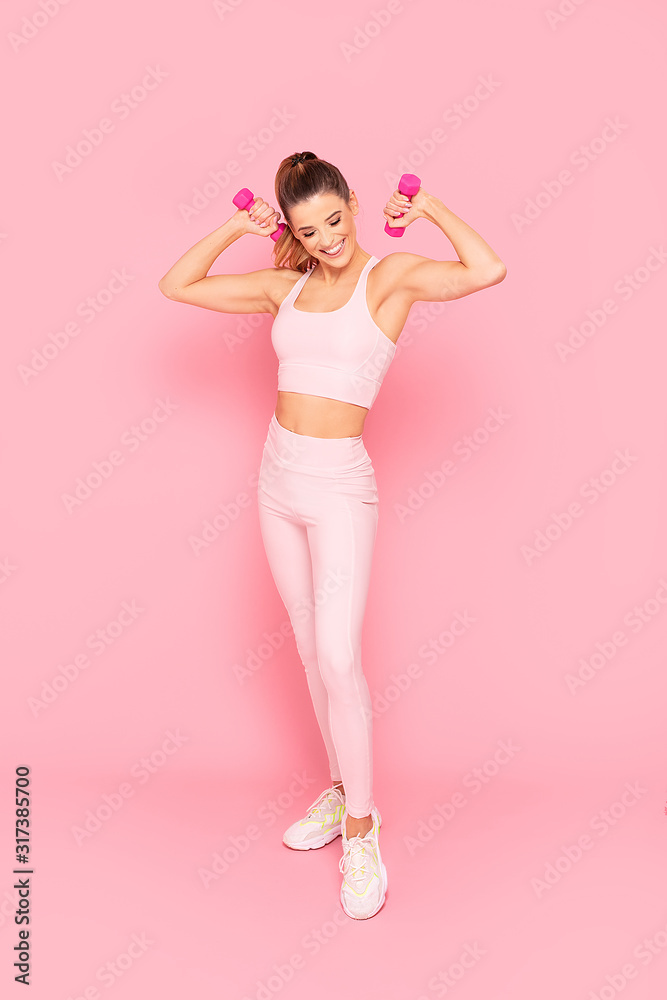 Smiling girl enjoying fitness training. - obrazy, fototapety, plakaty 