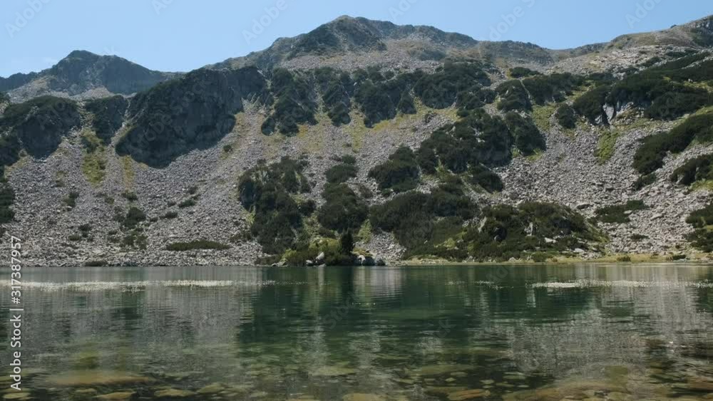 Panorama of beautiful green mountains, blue sky, flying birds and the calm surface of a mountain lake in summer on a sunny day. Idyll in nature. Relax Panorama of beautiful green mountains, blue sky, flying birds and the calm surface of a mountain lake in summer on a sunny day. Idyll in nature. Relax
