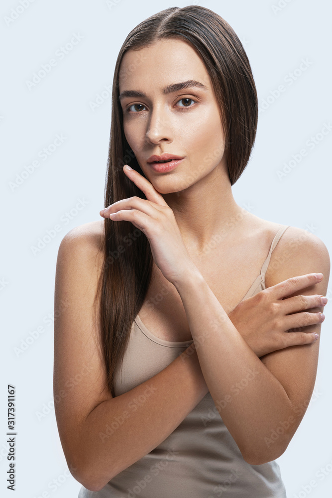 Charming tender girl posing for camera against light background Charming tender girl posing for camera against light background