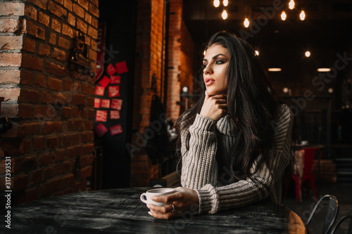 Beautiful woman drinking coffee sitting in a cafe.