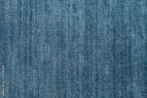 Structure of cotton jeans. Texture of blue denim fabric for background and design. Aquamarine tone.