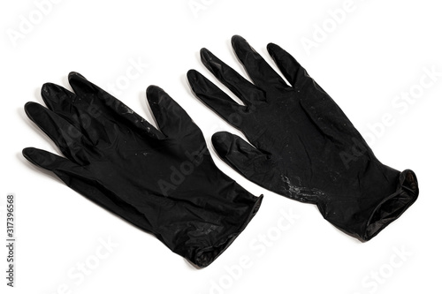 A pair of thin black latex gloves on a white background. Used disposable dirty rubber gloves. Protective subject.