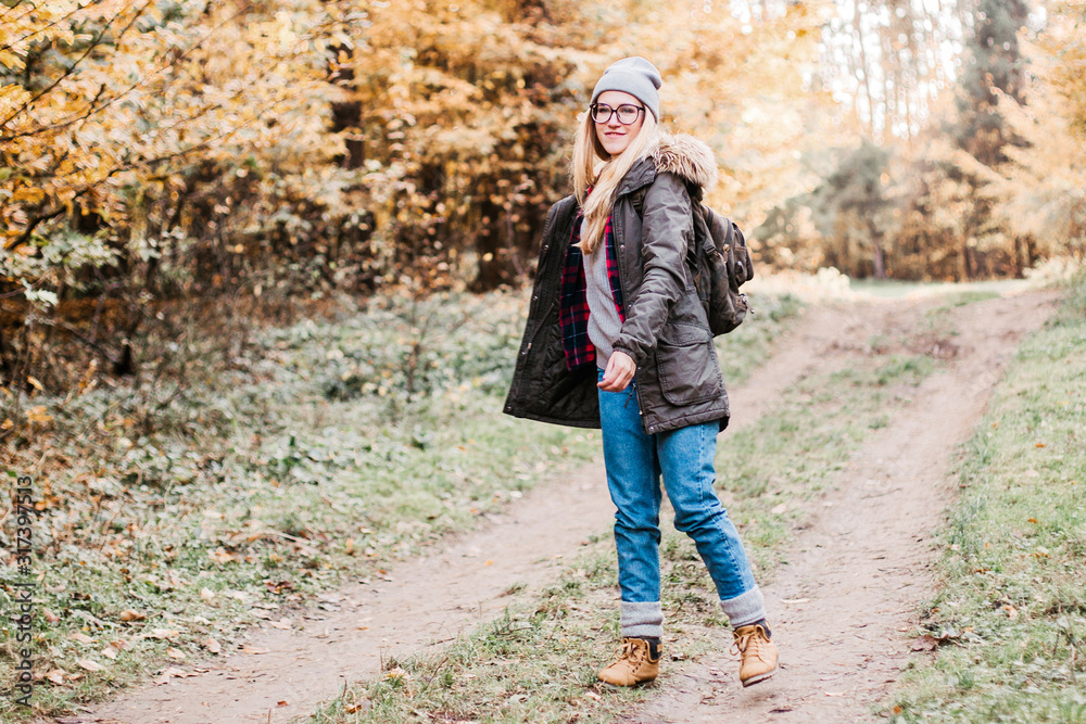 Hiking and travel along in the forest. Concept of trekking, adventure and seasonal vacation. Young woman walking in woods.