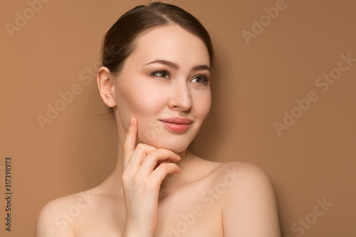 a woman with clean skin touches her cheeks with her hand. Perfect facial skin concept. nude makeup.