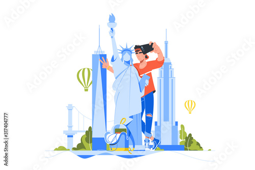 Young handsome man makes selfie with statue of liberty.