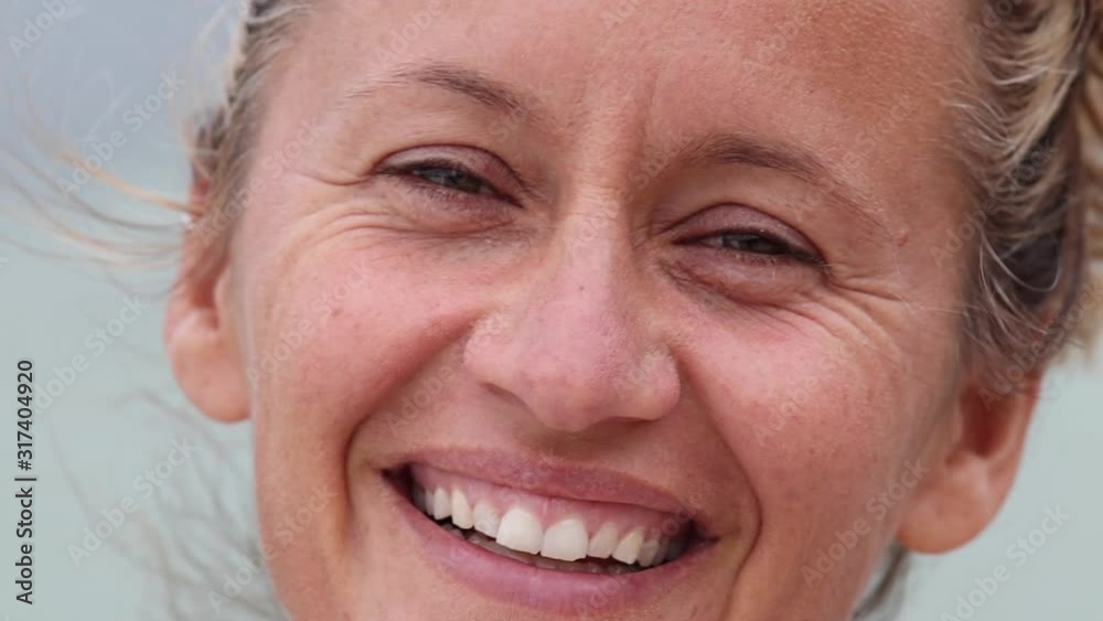 Close up of happy Australian woman in her 30s laughing outdoors at the beach in cinematic slow motion Close up of happy Australian woman in her 30s laughing outdoors at the beach in cinematic slow motion