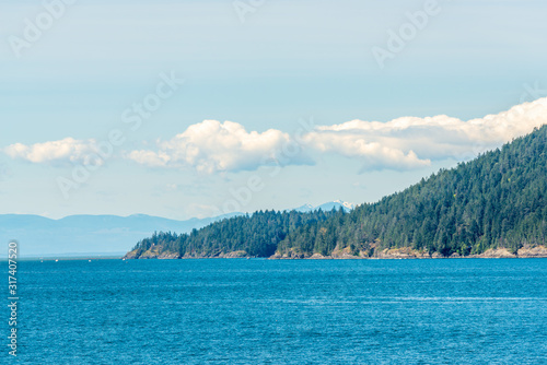View over inlet, ocean and island with boat and mountains in beautiful British Columbia. Canada.