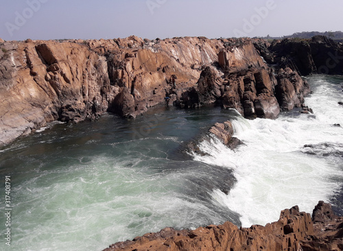 Sopheakmit or Preah Nimith waterfall with blue sky in background, Islands with Brown Cliffs with Green rapids and large waterfalls in the Mekong River, Stung Treng, Cambodia