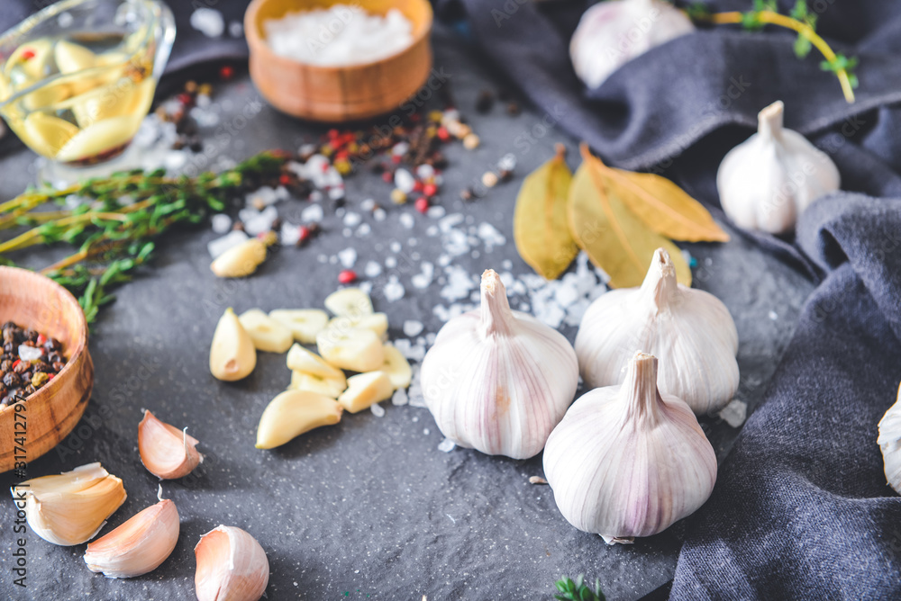 Fresh garlic with spices on dark background