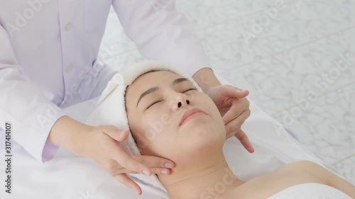 Therapist doing Tuina massage at face of young woman , chinese alternative medicine.