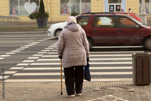 Konstfotografi old woman, a lady with a cane, a pedestrian crosses the street, avenue
