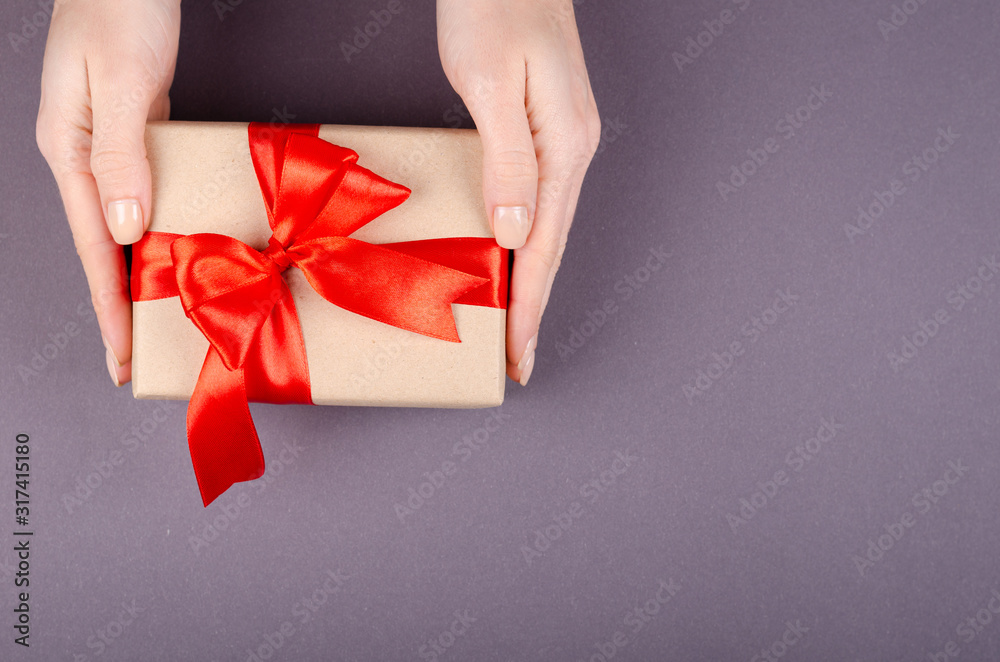 Hands with gift box on dark background composition, present with ribbon and bow. Hands with gift box on dark background composition, present with ribbon and bow.
