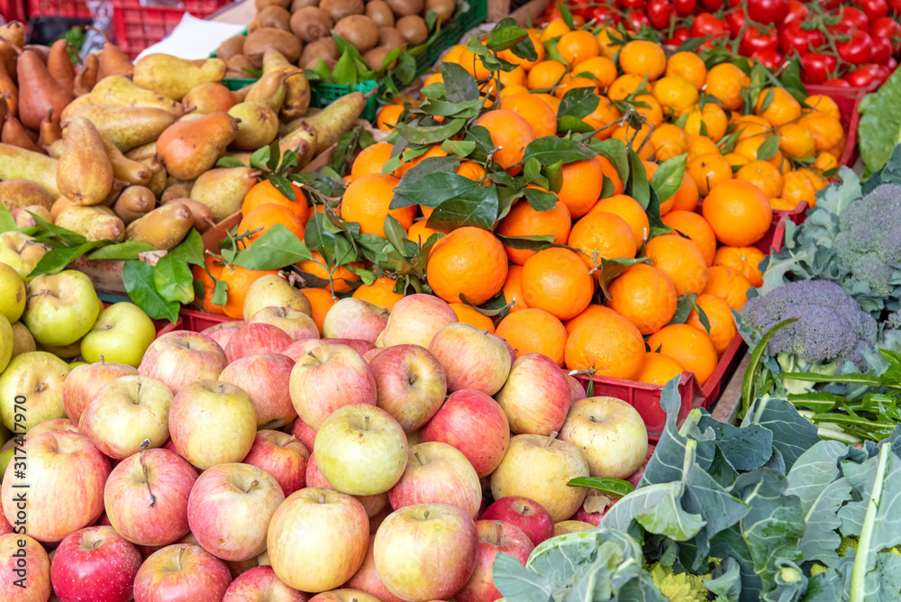 Apples, tangerines and other fruits and vegetables for sale at a market