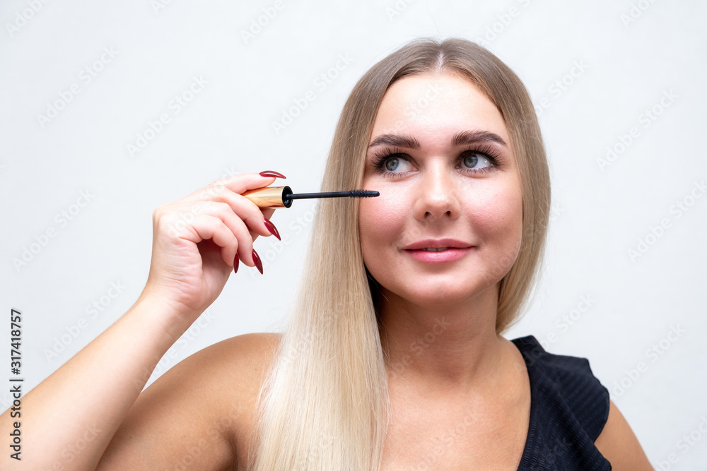 Fototapeta premium Makeup. Make-Up. Applying Mascara. Long Eyelashes. Woman applying eye mascara to her eyelashes.