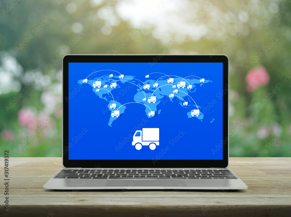 Delivery truck icon with connection line and world map on modern laptop computer screen on wooden table over blur pink flower and tree in garden, Business transportation online concept Delivery truck icon with connection line and world map on modern laptop computer screen on wooden table over blur pink flower and tree in garden, Business transportation online concept