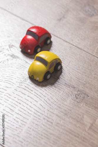 Red and yellow toy cars on a wooden floor