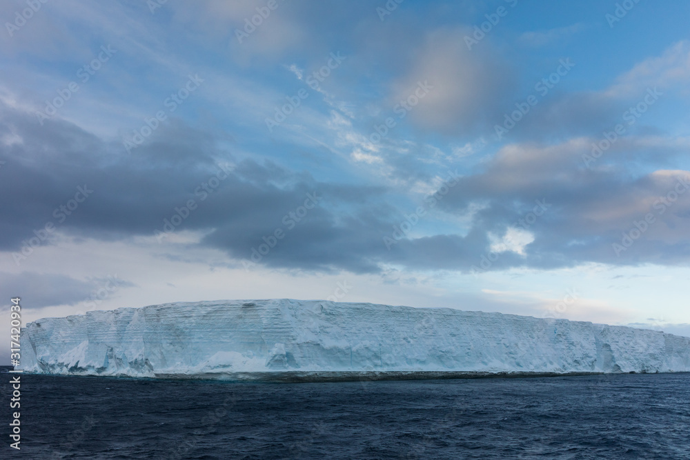 Large tabular iceberg floating in the cold water of Antarctica