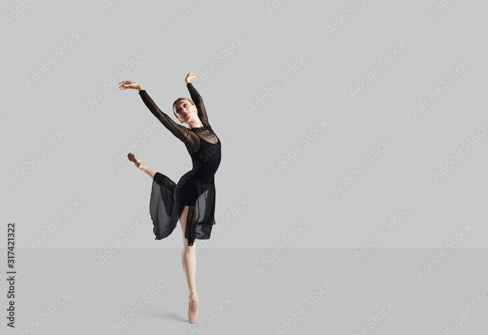 Woman ballet dancer over gray background.