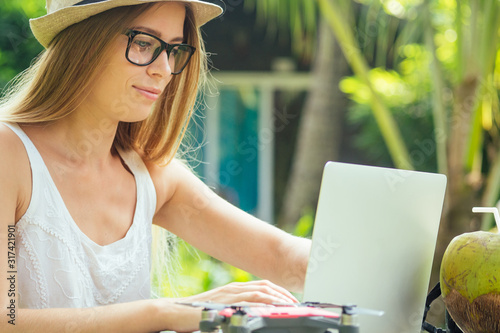 Photography photographer blonde female working outdoor retoucher and drinking coconut